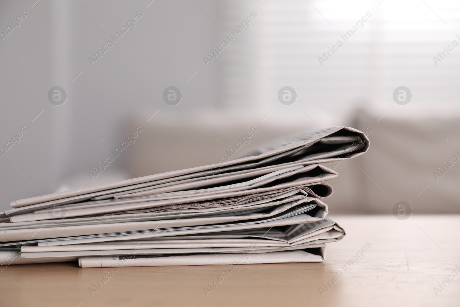 Photo of Stack of newspapers in different languages on table indoors