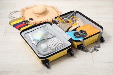 Open suitcase with traveler's belongings on floor