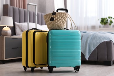 Photo of Color suitcases, bag and sunglasses in bedroom