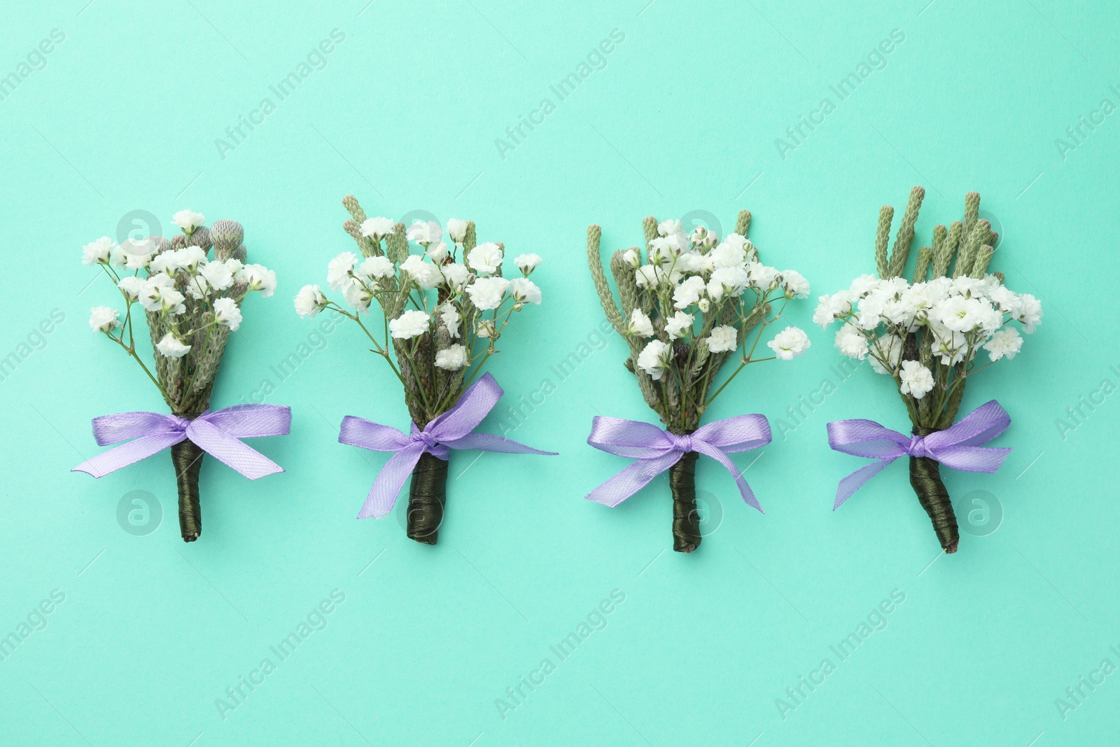 Photo of Many stylish boutonnieres on turquoise background, flat lay