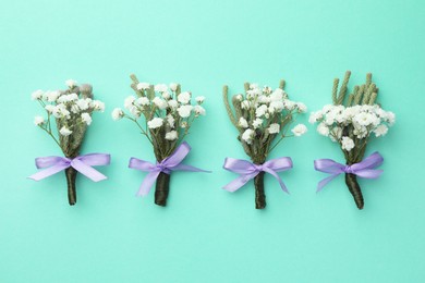 Many stylish boutonnieres on turquoise background, flat lay