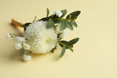 Small stylish boutonniere on beige background, closeup