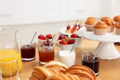 Different meals served on wooden table indoors. Buffet menu