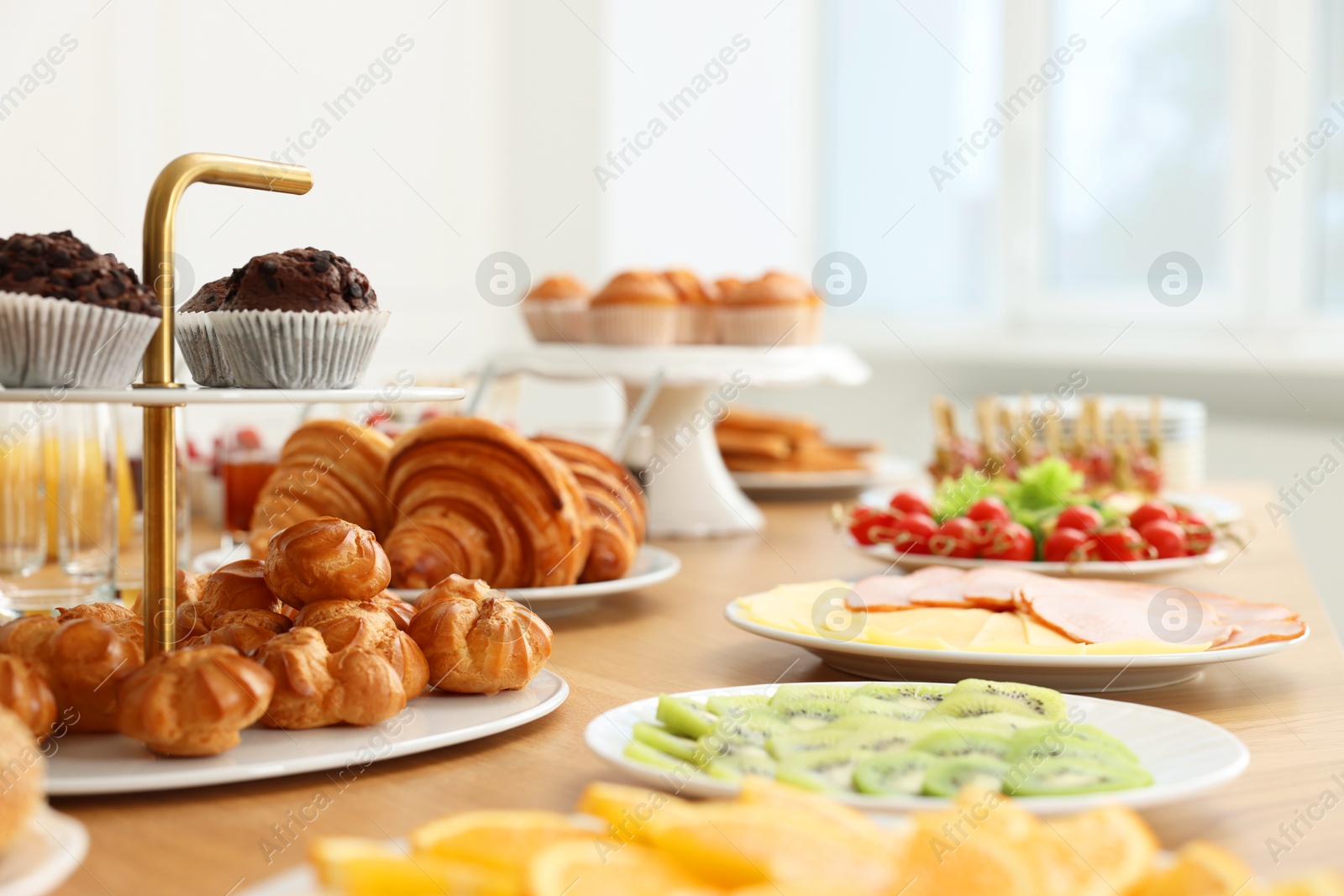 Photo of Different meals served on wooden table indoors, selective focus. Buffet menu