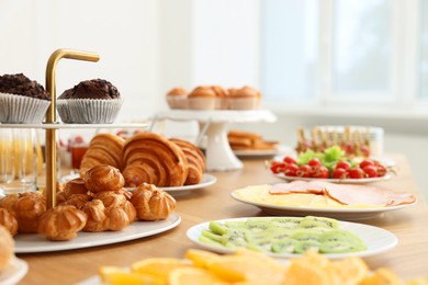 Photo of Different meals served on wooden table indoors, selective focus. Buffet menu