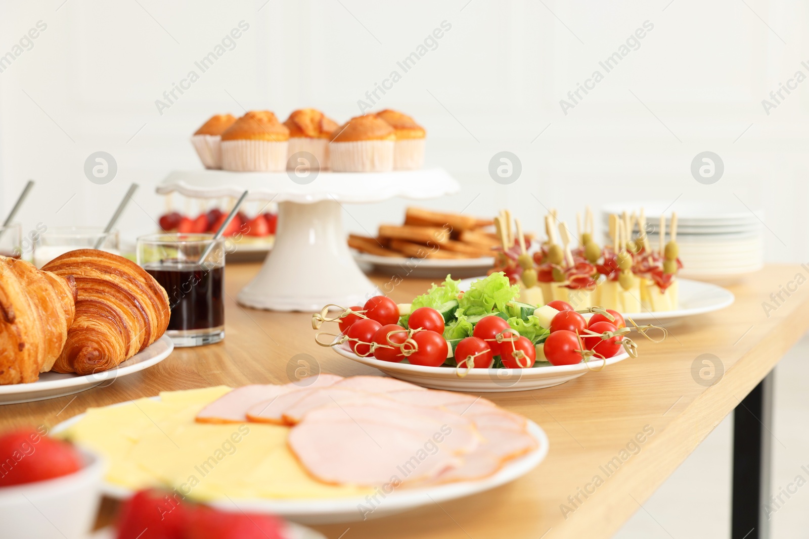 Photo of Different meals served on wooden table indoors, selective focus. Buffet menu