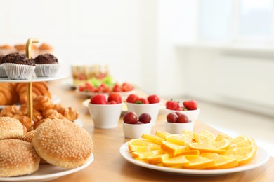 Photo of Different meals served on wooden table indoors, closeup. Buffet menu