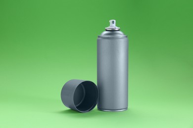 Gray spray paint can on green background