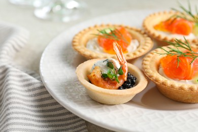 Photo of Delicious canapes with shrimp, salmon and caviar on table, closeup