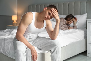 Photo of Offended couple ignoring each other in bedroom. Relationship problem