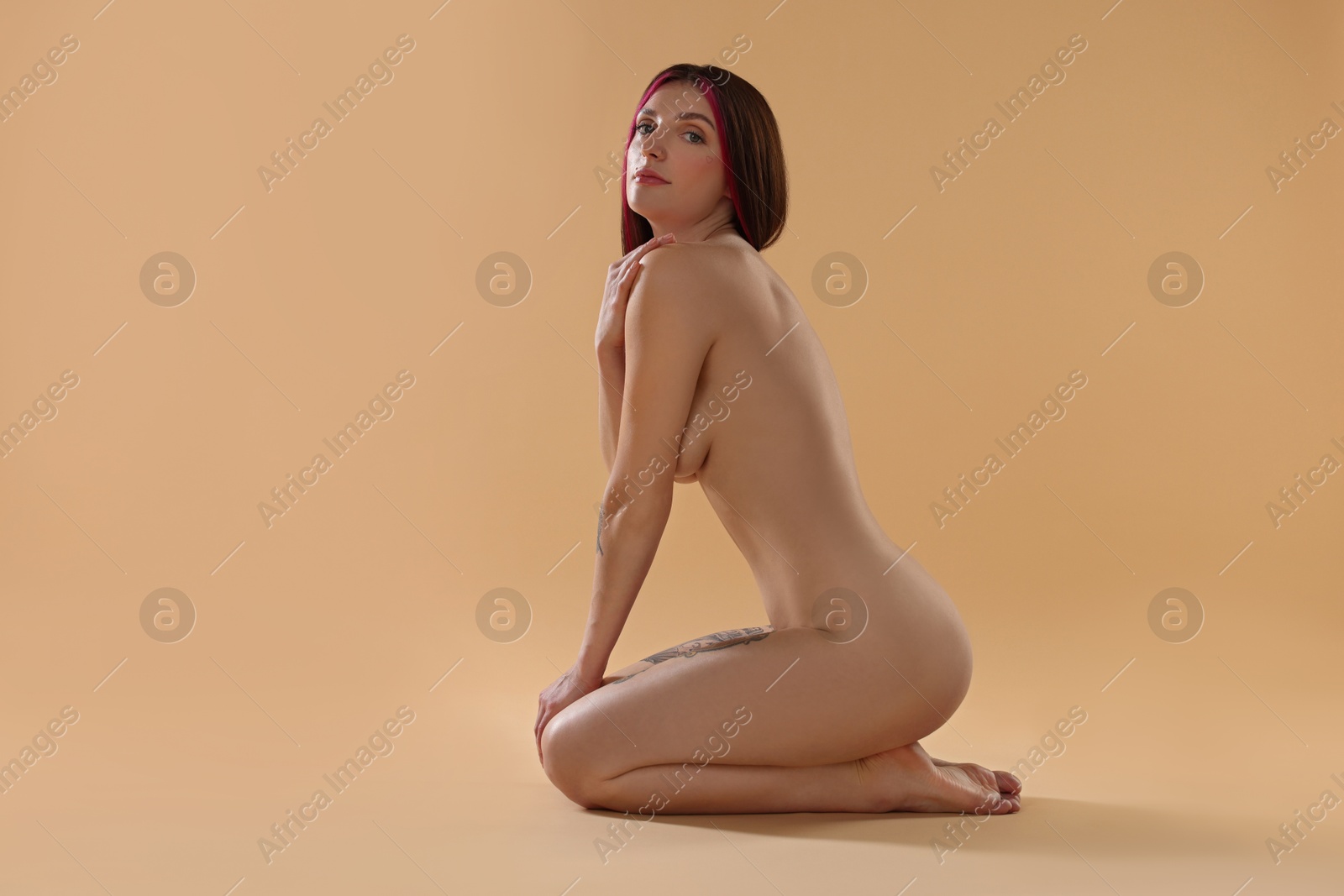 Photo of Sexy nude woman posing on beige background