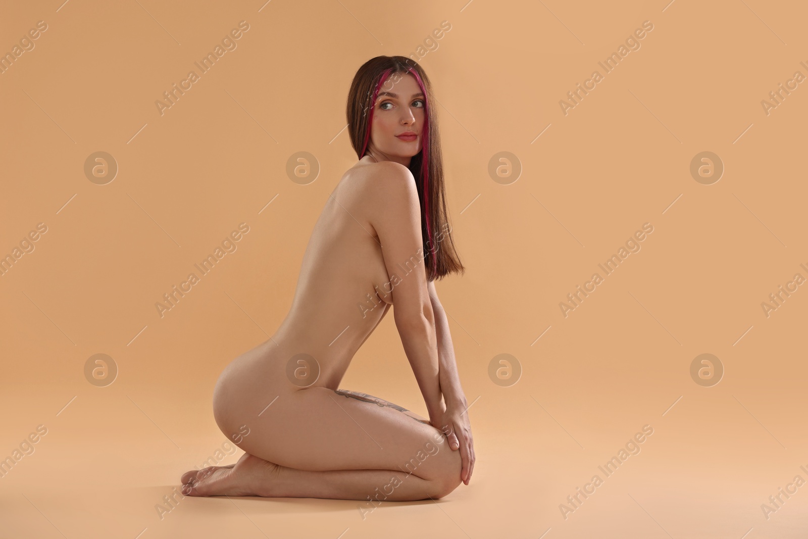 Photo of Sexy nude woman posing on beige background, space for text