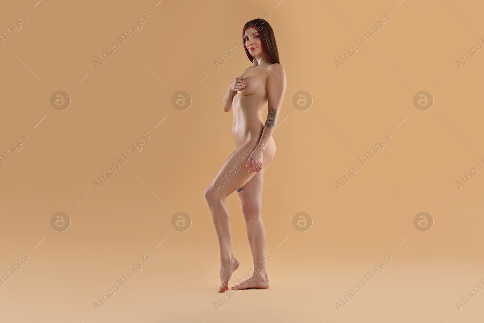 Photo of Full length portrait of sexy nude woman on beige background