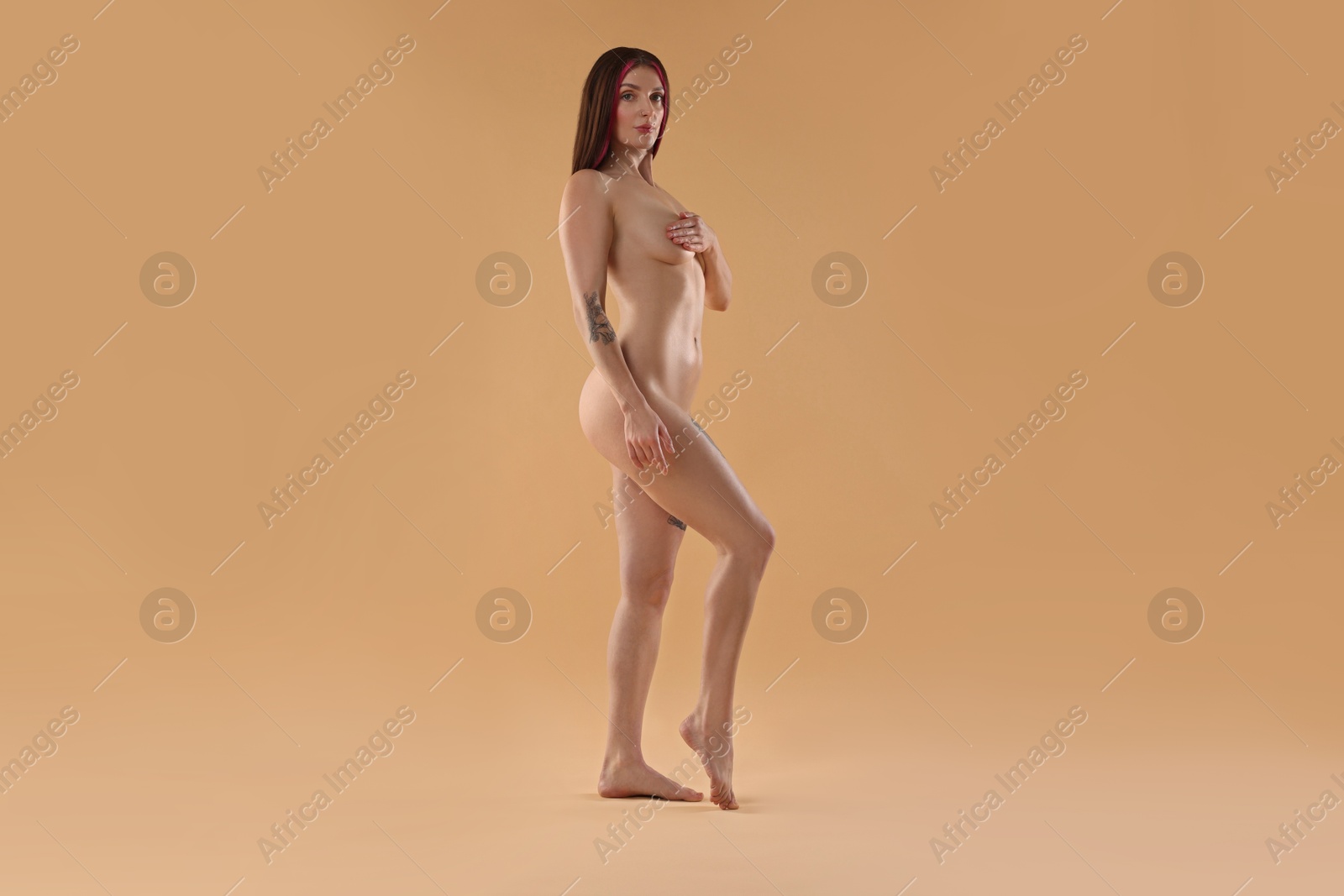 Photo of Full length portrait of sexy nude woman on beige background