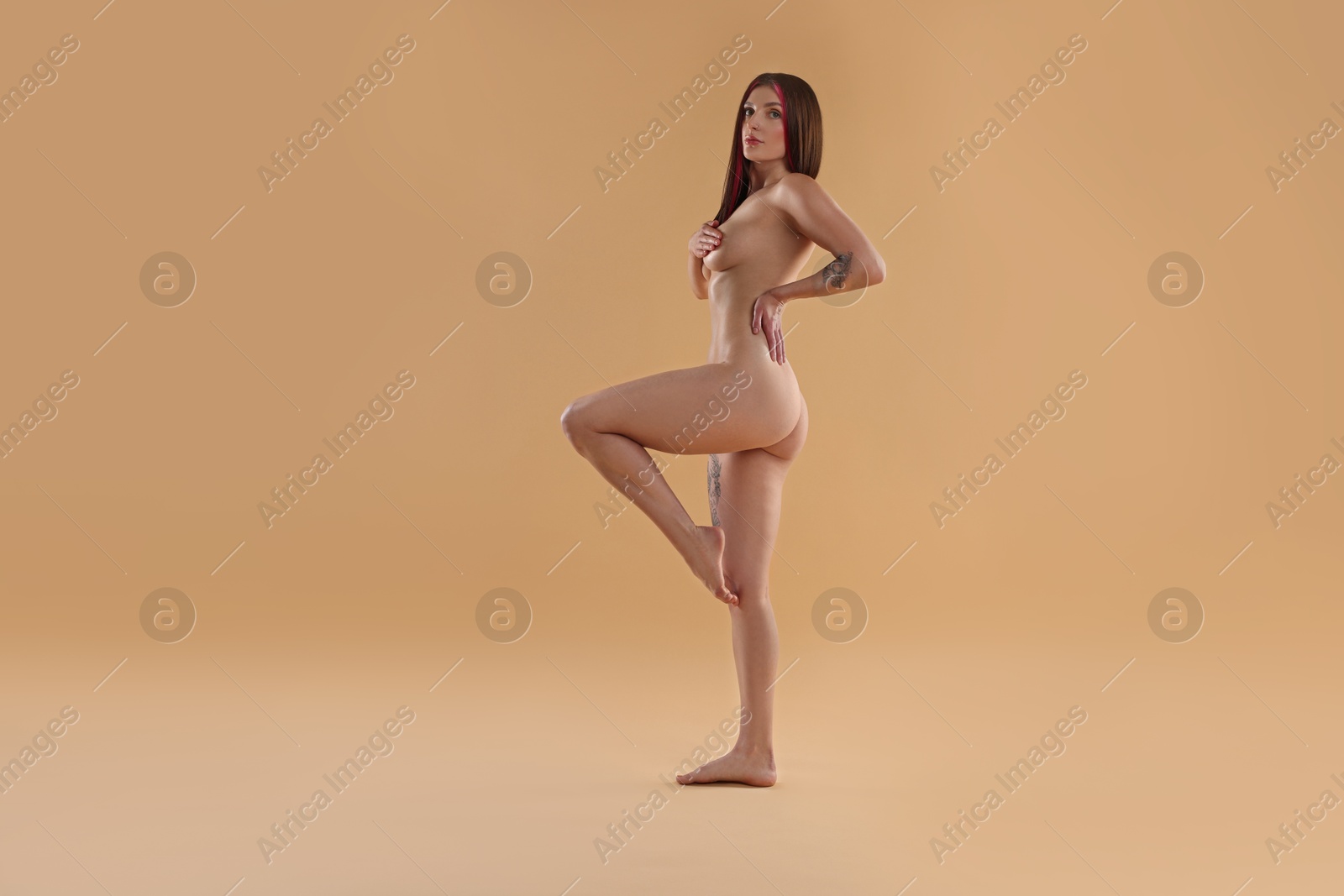 Photo of Full length portrait of sexy nude woman on beige background