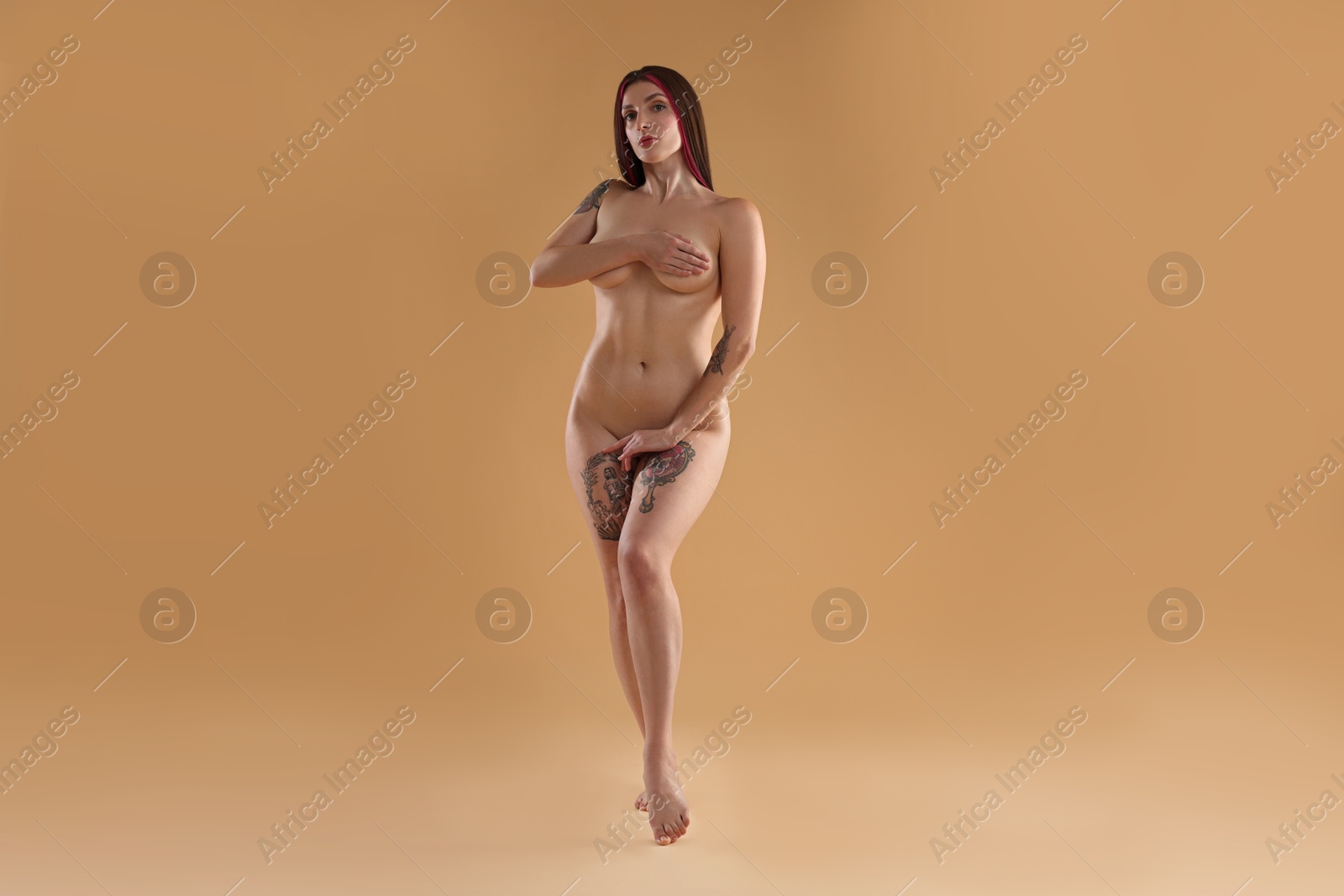 Photo of Full length portrait of sexy nude woman on beige background