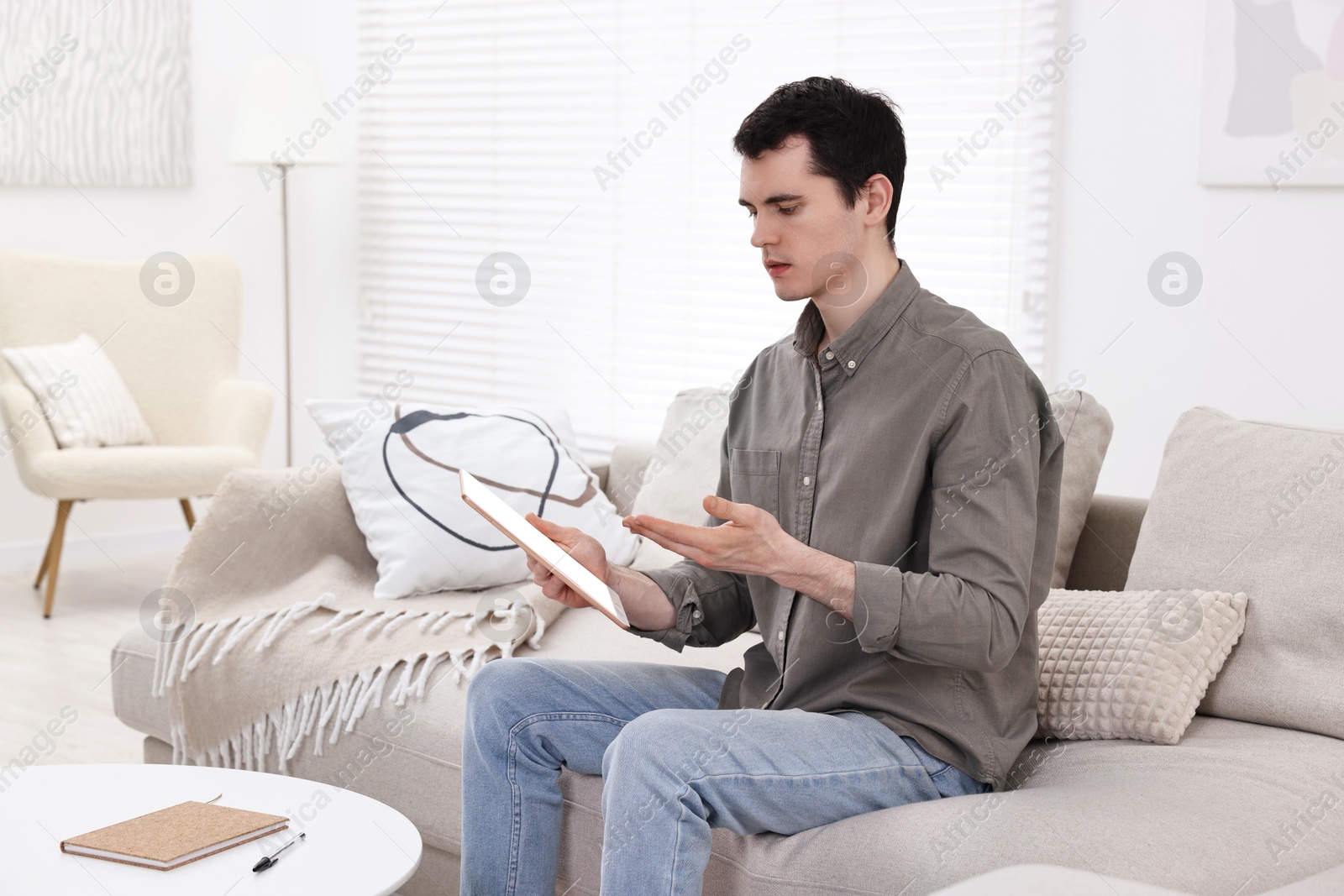 Photo of Sick man having online consultation with doctor via tablet at home