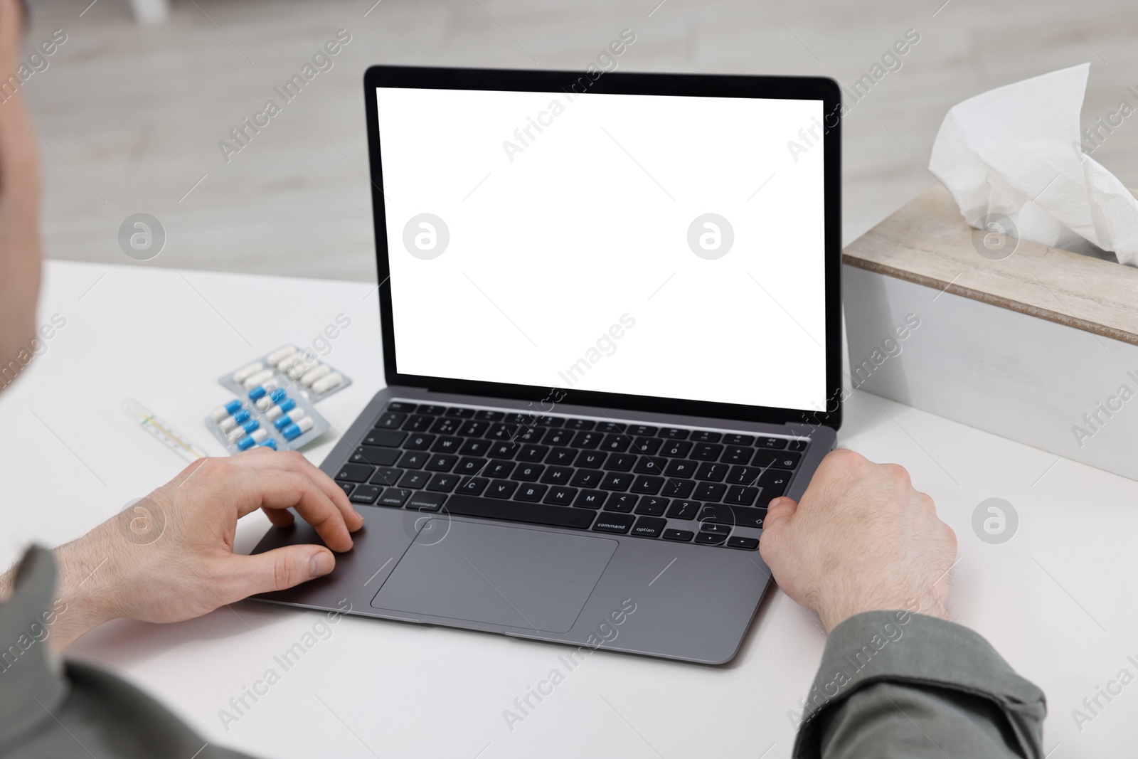 Photo of Sick man having online consultation with doctor via laptop at white table indoors, closeup