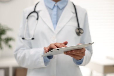 Photo of Doctor using tablet in hospital, closeup view