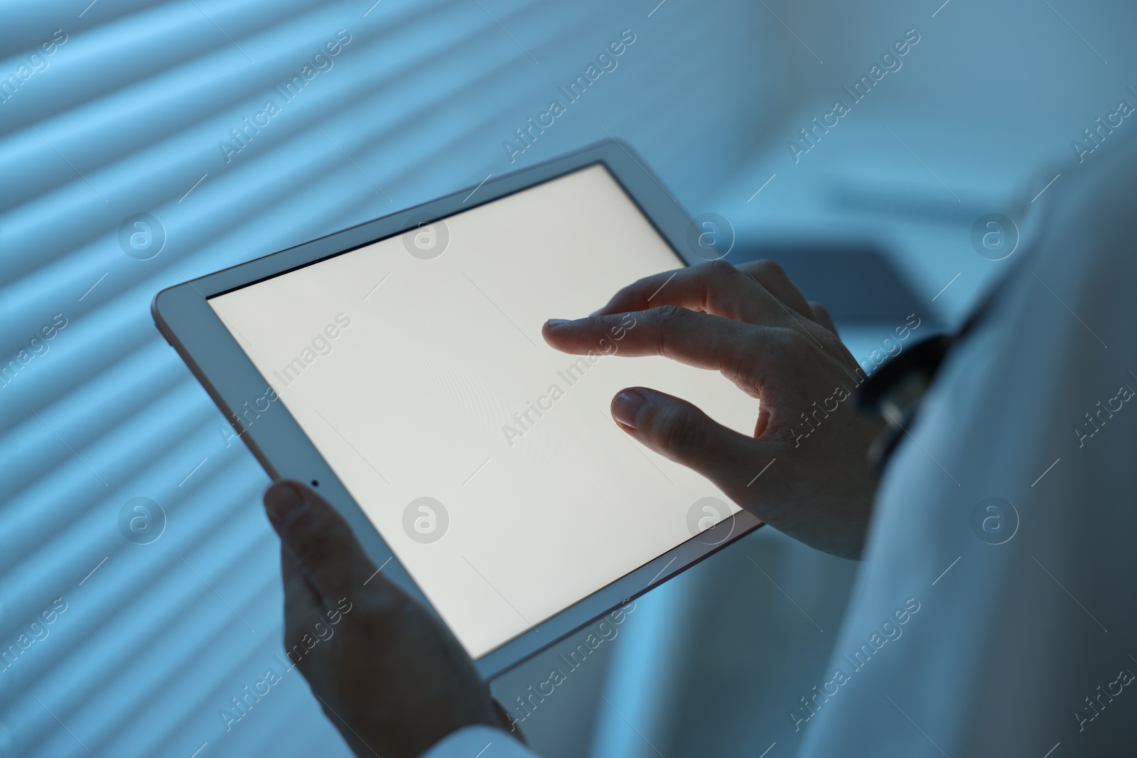 Photo of Doctor using tablet in hospital at night, closeup