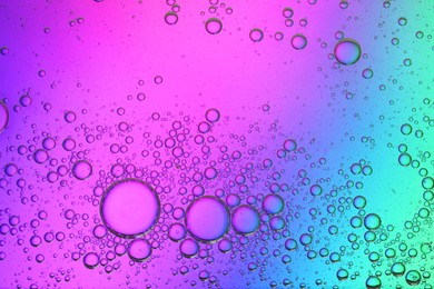 Photo of Essential oil bubbles on color background, top view. Cosmetic product