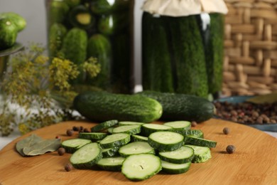 Photo of Board with fresh cucumbers and spices on table, closeup