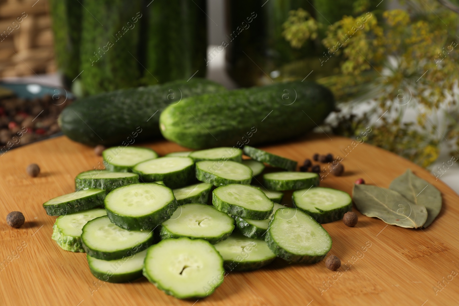 Photo of Board with fresh cucumbers and spices on table, closeup