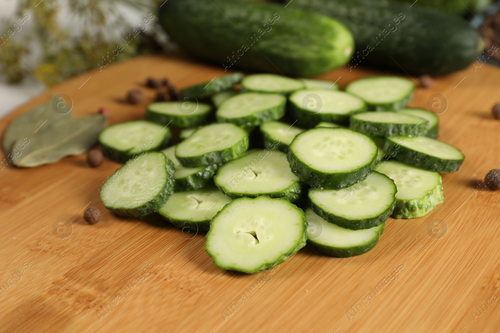 Photo of Board with fresh cucumbers and spices on table, closeup