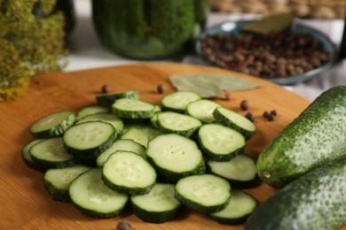 Board with fresh cucumbers and spices on table, closeup