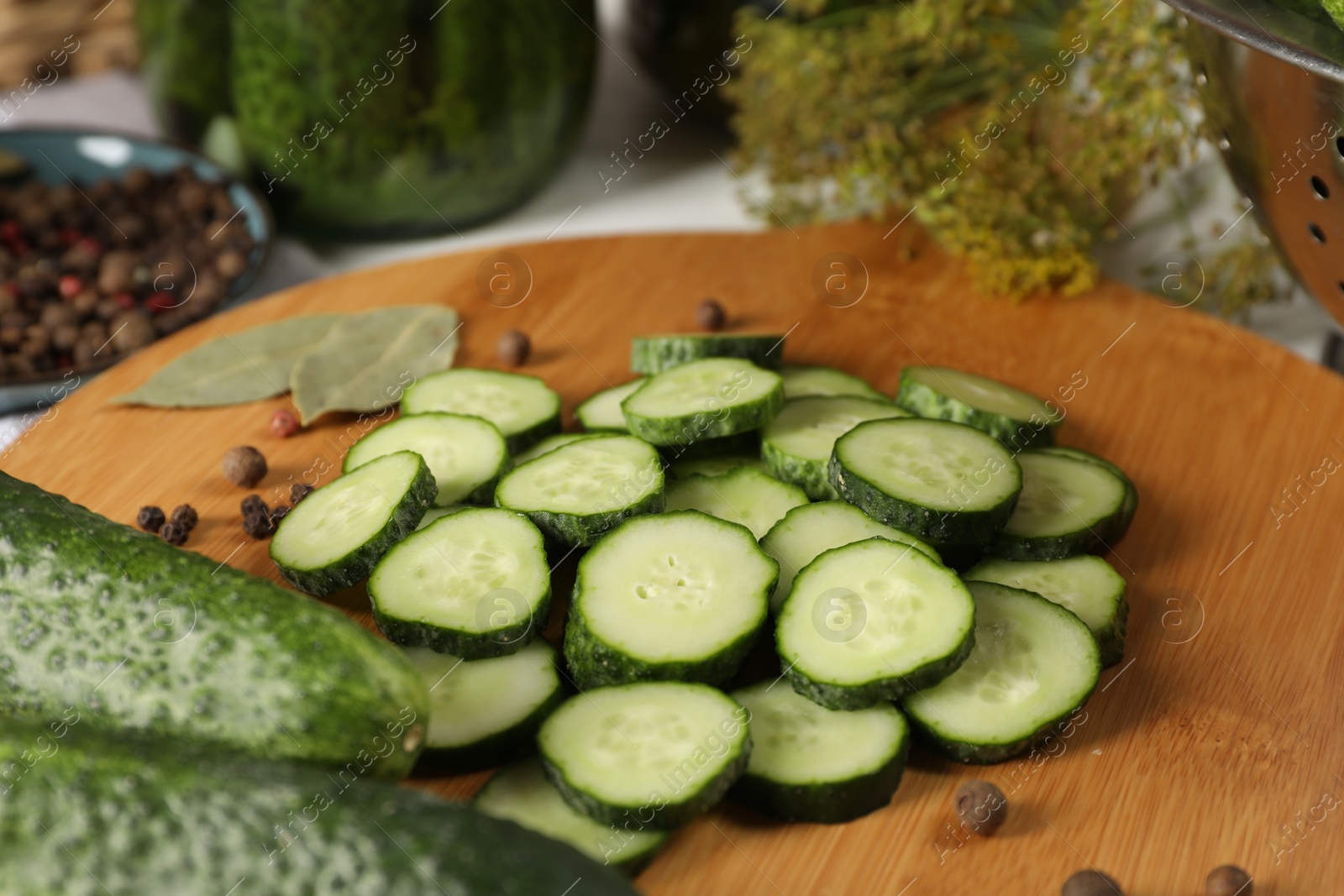 Photo of Board with fresh cucumbers and spices on table, closeup