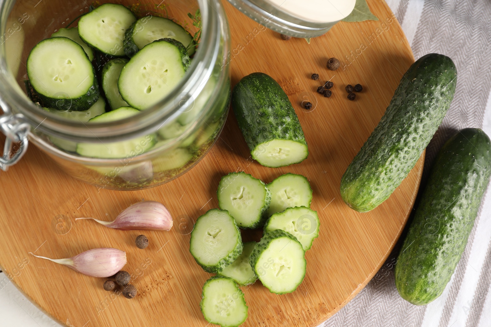 Photo of Board with fresh cucumbers and spices on table, above view