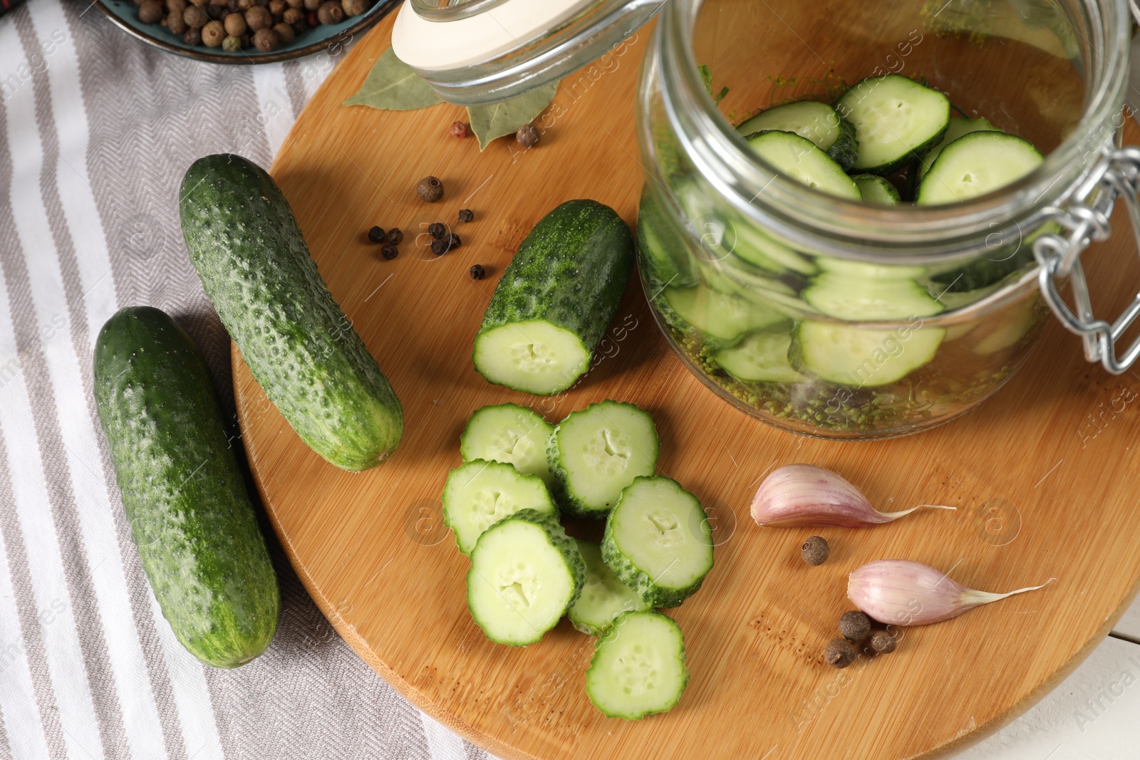 Photo of Board with fresh cucumbers and spices on table, above view