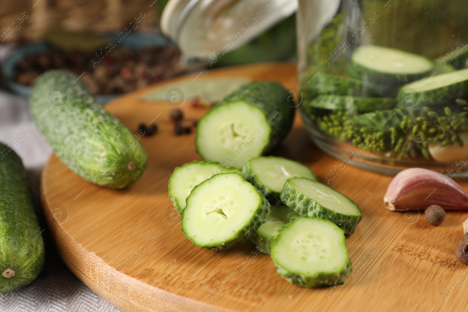 Photo of Board with fresh cucumbers and spices on table, closeup