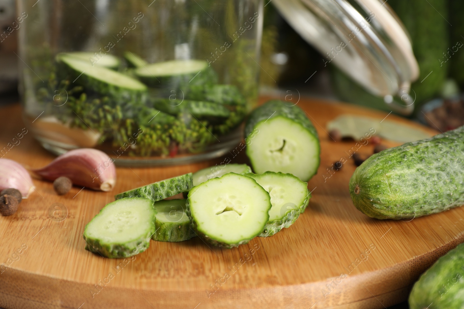 Photo of Board with fresh cucumbers and spices on table, closeup