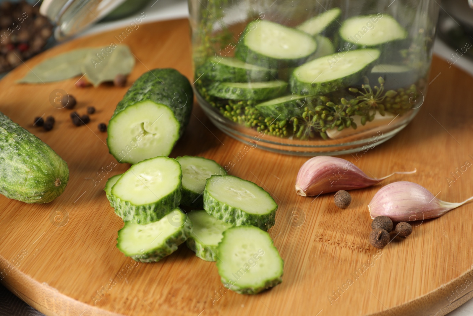 Photo of Board with fresh cucumbers and spices on table, closeup