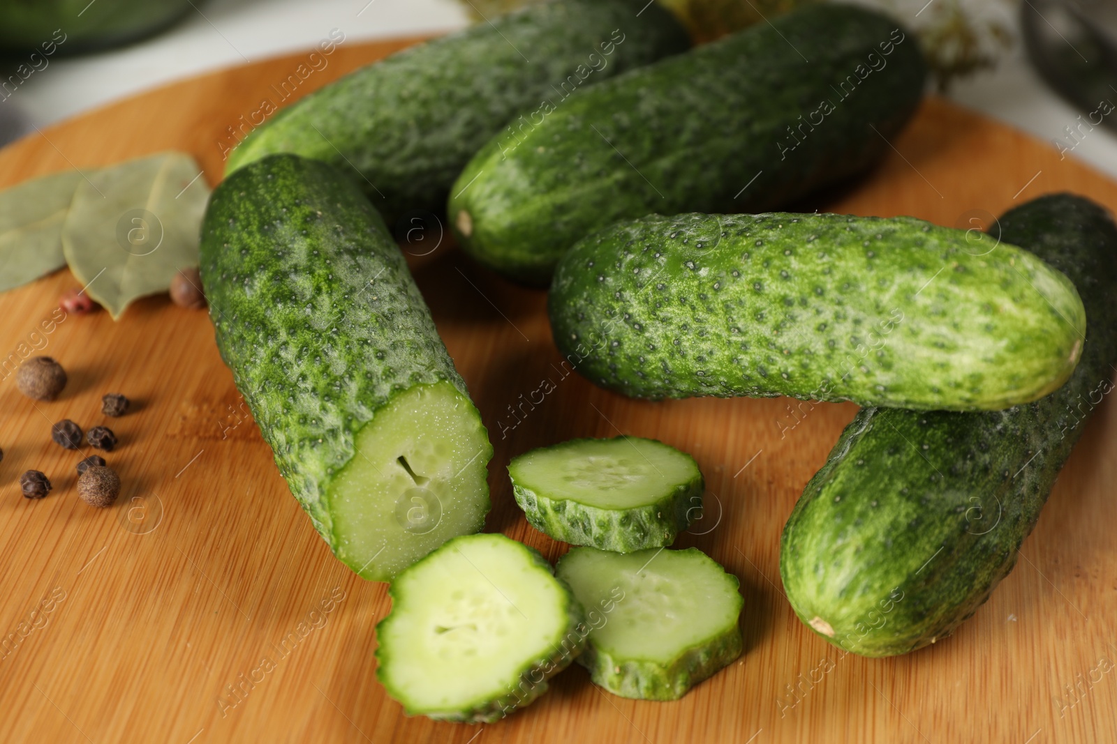 Photo of Board with fresh cucumbers and spices on table, closeup