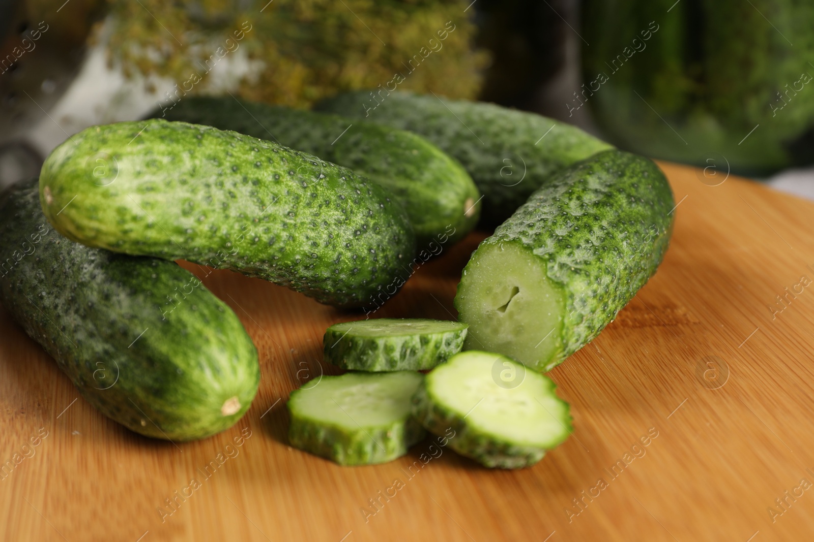 Photo of Board with fresh cucumbers on table, closeup