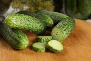 Board with fresh cucumbers on table, closeup