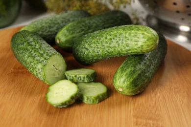 Photo of Board with fresh cucumbers on table, closeup