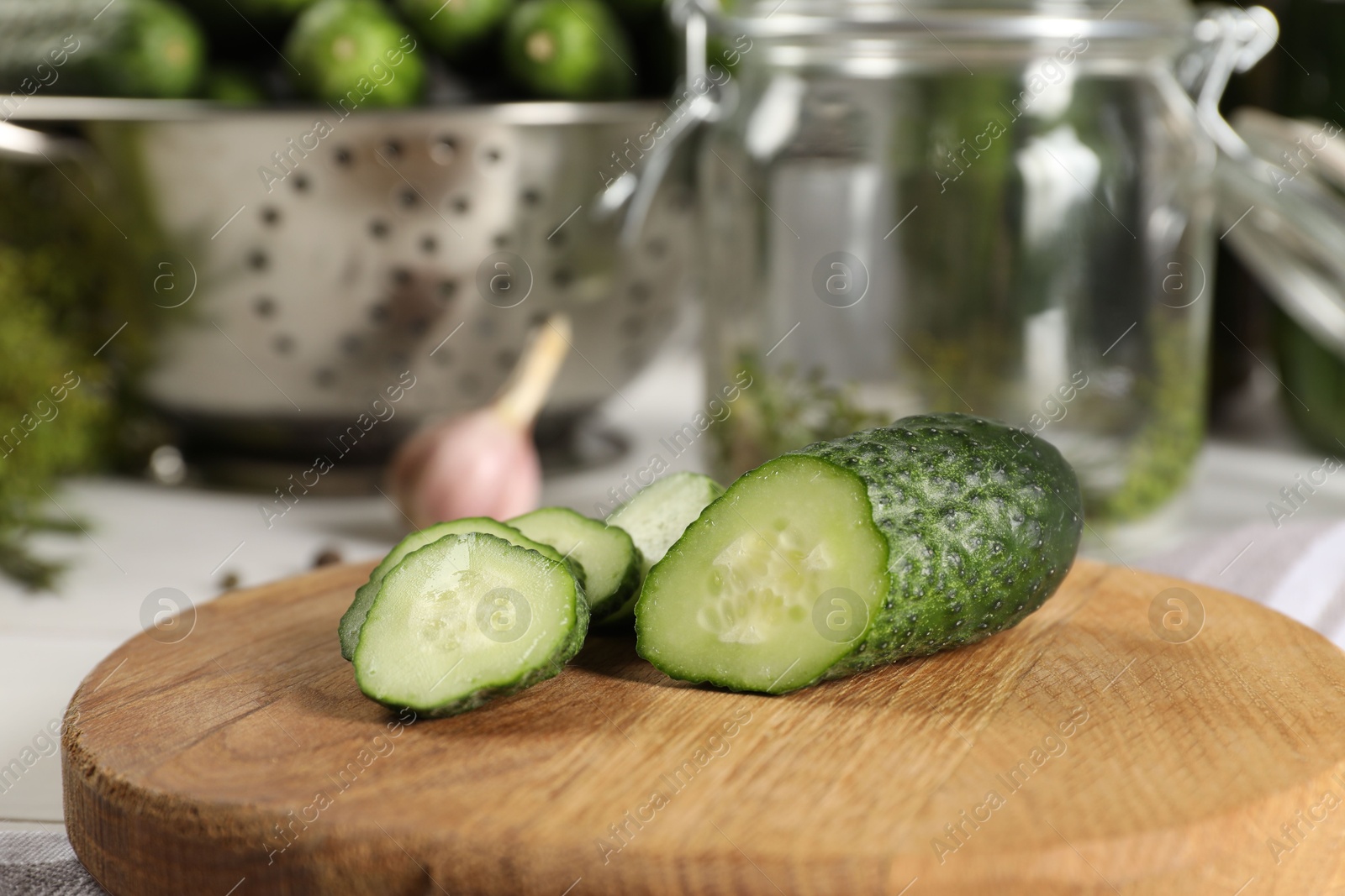 Photo of Board with fresh cut cucumber on light table, closeup