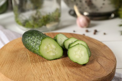 Photo of Board with fresh cut cucumber on light table, closeup