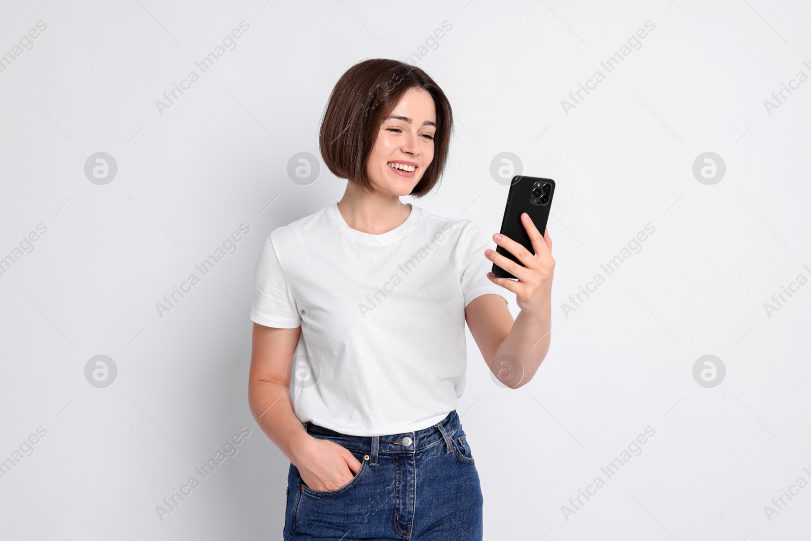 Photo of Happy woman with smartphone on white background