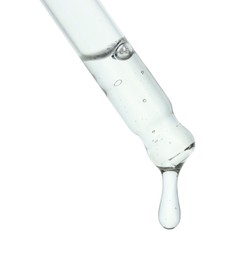 Dripping cosmetic serum from pipette on white background, closeup