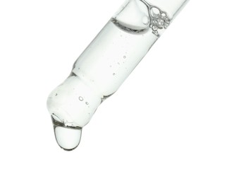 Photo of Dripping cosmetic serum from pipette on white background, closeup