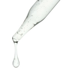 Photo of Dripping cosmetic serum from pipette on white background, closeup