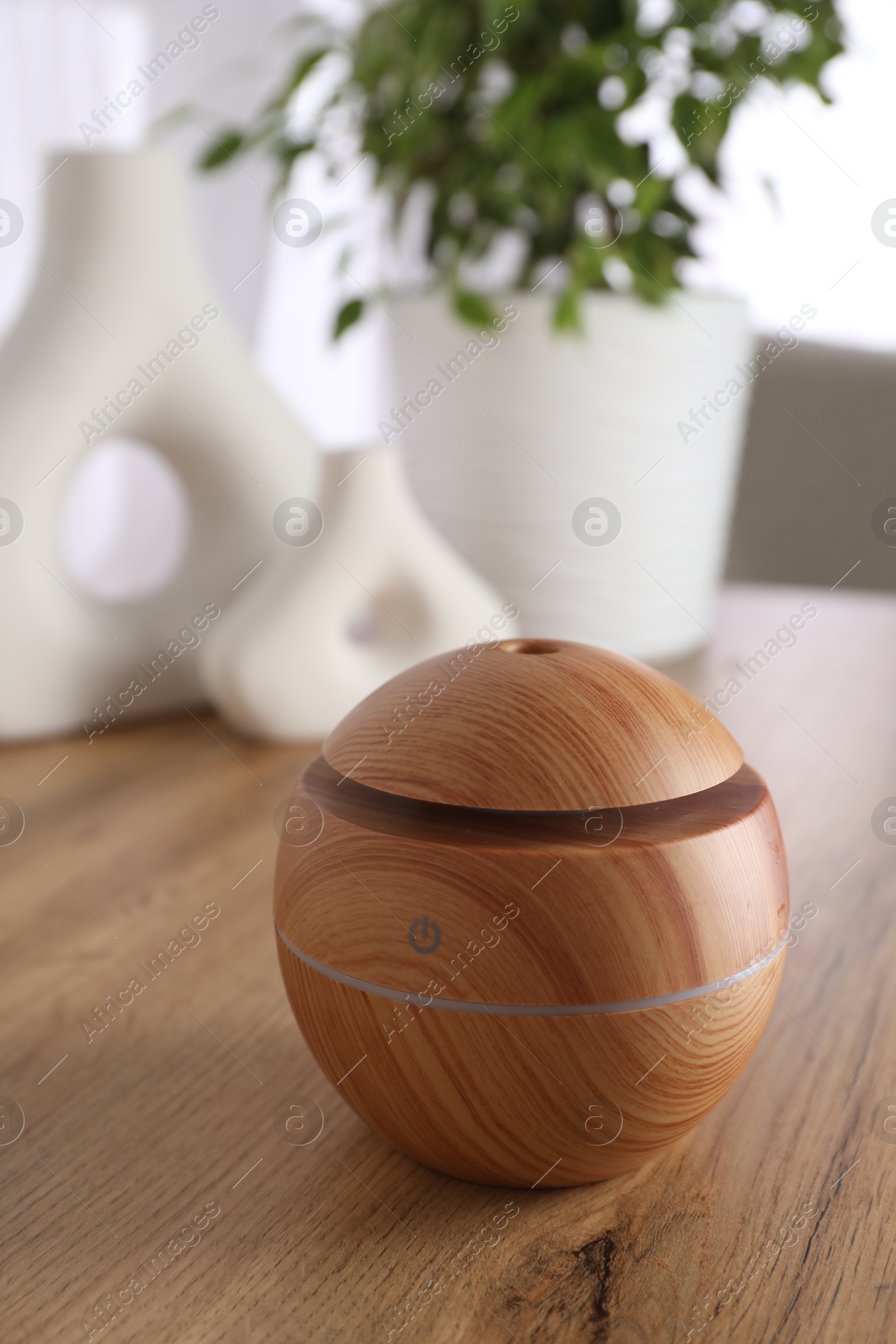 Photo of Essential oil diffuser on wooden table at home