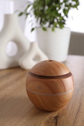 Photo of Essential oil diffuser on wooden table at home