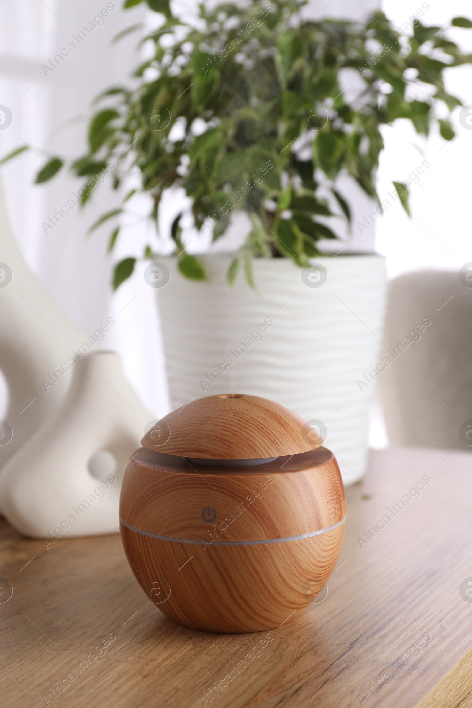 Photo of Essential oil diffuser on wooden table at home