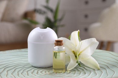 Photo of Essential oil diffuser, cosmetic product and lily flower on table at home