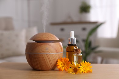 Essential oil diffuser, cosmetic products and calendula flowers on wooden table at home